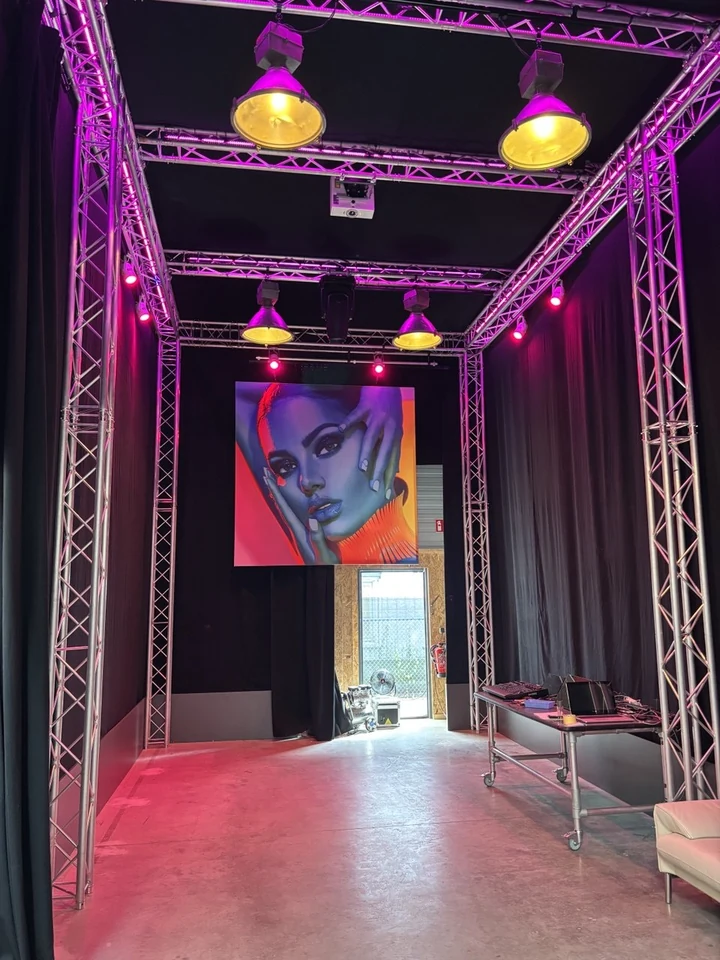 De zwarte showbooth in de Bredase studio van So-light, met truss, licht en projectie